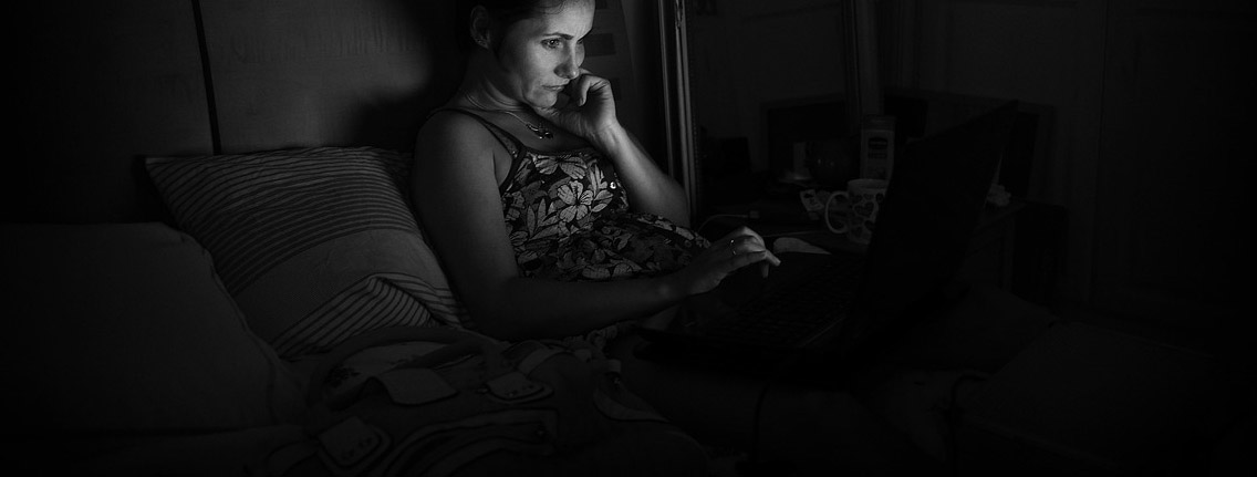 girl looking at a laptop in a dark room