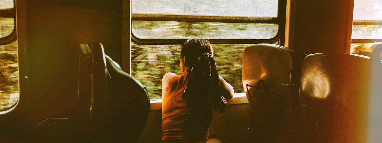 unrecognizable woman riding train and looking out window